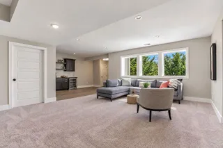 Plush carpeting and recessed lighting define this versatile basement living space with a wet bar. PHOTO IS OF ACTUAL HOME.