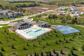 A spacious community recreation area includes a sparkling swimming pool and dual sports courts.