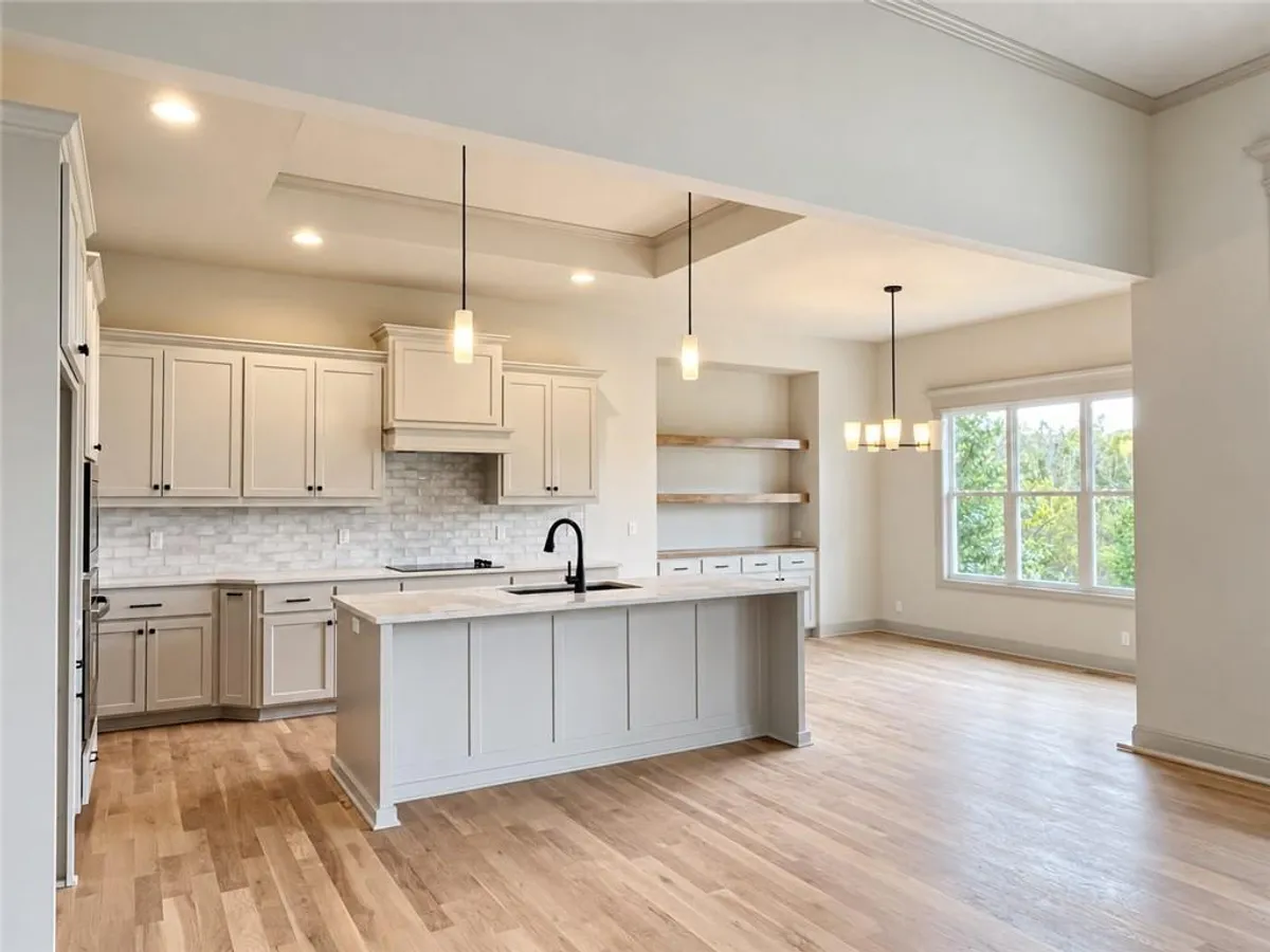 Gleaming hardwood floors and clean-lined cabinetry define this elegant open-concept culinary space. PHOTO IS OF ACTUAL HOME