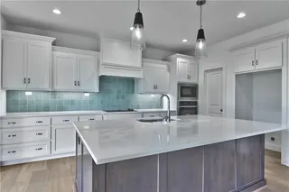 Large kitchen island and stainless appliances.  Picture is of the actual home.
