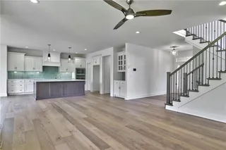 Great room view into kitchen.  Large island, stainless appliances, hardwood floors. Picture is of the actual home.