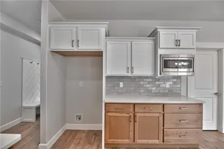 PHOTOS ARE OF ACTUAL HOME. View of Kitchen with upgraded Kitchen Tile Backsplash, Soft Close Drawers, Quartz Counter Tops, Super Single Stainless Steel Sink Apron Sink with SS Appliances, Walk in Pantry and Gas Stove.