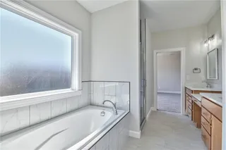 PHOTOS ARE OF ACTUAL HOME. Master Bathroom with upgraded Rectangular Under mount sinks, Quartz Counter Tops, Make Up Table, Soaker Tub, Privacy Glass over Tub, Euro Walk in Shower with Accent Tile and Bench.