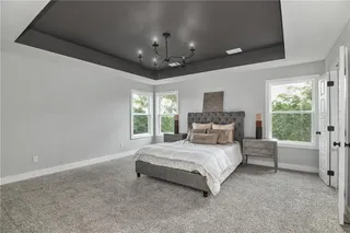 PICTURE IS OF THE ACTUAL HOME. SPACIOUS MASTER BEDROOM FEATURES A DARK TRAY VAULTED CEILING.