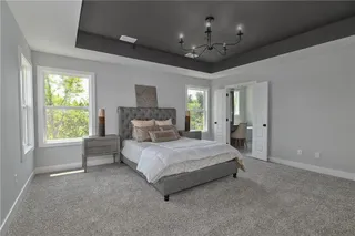 PICTURE IS OF THE ACTUAL HOME. SPACIOUS MASTER BEDROOM FEATURES A DARK TRAY VAULTED CEILING.