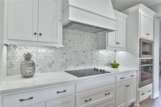PICTURE IS OF THE ACTUAL HOME. KITCHEN FEATURES GRANITE COUNTERTOPS AND DESIGNER HEXAGON TILE BACKSPLASH.