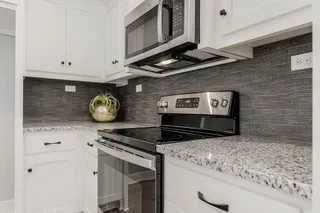  GRANITE COUNTERS PLUS WHITE CABINETS WITH STAINLESS APPLIANCES.  PHOTOS ARE OF THE ACTUAL HOME.