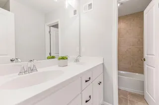 HALL BATH ON SECOND LEVEL. DOUBLE SINKS, SHOWER OVER TUB.  PHOTOS ARE OF THE ACTUAL HOME.