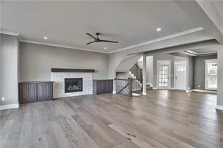 Great Room with Stone Front Gas Fireplace Flanked by Cabinets. PICTURE IS OF ACTUAL HOME.