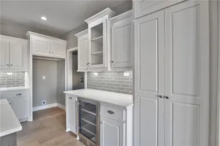 Dry Bar with Beverage Fridge and Double Doors lead you to Huge Walk In Pantry. PICTURE IS OF ACTUAL HOME. 