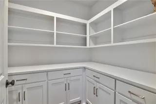 Walk In Pantry with Upper Shelves and lower cabinets. So much storage space! Picture is of Actual Home.