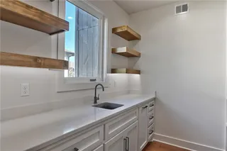 PICTURES ARE OF ACTUAL HOME.  Upgraded pantry includes floating shelves, cabinets, and sink. 