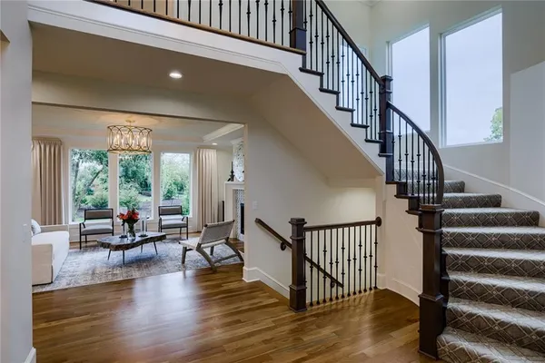Stairway featuring dark hardwood / wood-style flooring, a towering ceiling, and a notable chandelier