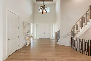 Grand entry with double doors and curved stairway