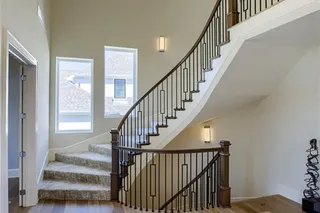 Photos of Previously Furnished Model Home-Floating curved staircase adds drama for your foyer entry.