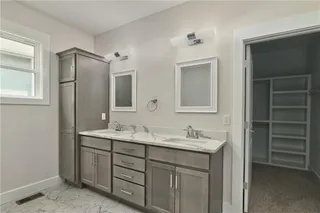 Pictures are of the actual home. Master bath features dual vanities with quartz counters, tower cabinet for storage, hexagon tile for the flooring. This shows entrance into the master closet.