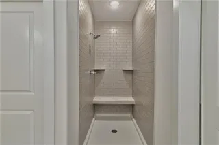 Pictures are of the actual home. Master shower features a bench and two shelves for toiletries.