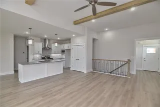 Pictures are of the actual home. Pantry doors just next to the refrigerator space. Island has breakfast bar. Stainless appliances including gas stove.