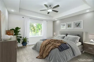 Master Bedroom features a tray vault ceiling and a ceiling fan.  Photo is virtually staged.