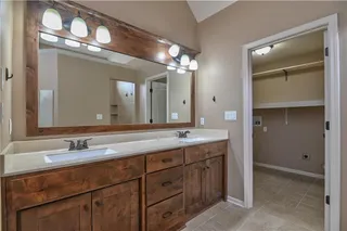 Primary bathroom includes a huge shower, two sinks, wood trim around mirror, nice size closet and laundry access.