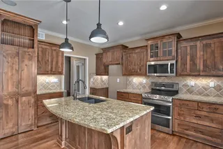 Large kitchen island with a breakfast bar, granite counter tops, and stainless appliances. Behind those doors is a huge walk-in pantry!