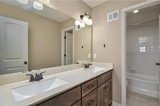 Secondary bathroom serves 3 bedrooms upstairs.  Includes two sinks and a shower over tub.