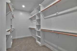 Pictures are of a Previous Model AND MAY FEATURE UPGRADES. SEVERAL BUYER SELECTIONS ARE STILL AVAILABLE. PLEASE CONTACT LISTING AGENT FOR DETAILS.Master Walk in closet with dark carpet