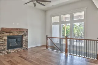 Pictures are of a Previous Model AND MAY FEATURE UPGRADES. SEVERAL BUYER SELECTIONS ARE STILL AVAILABLE. PLEASE CONTACT LISTING AGENT FOR DETAILS.Unfurnished living room featuring dark hardwood / wood-style floors, ceiling fan, and a fireplace