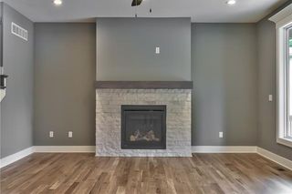 Great Room with Hardwood Floors and Stone Front Gas Fireplace with Mantel