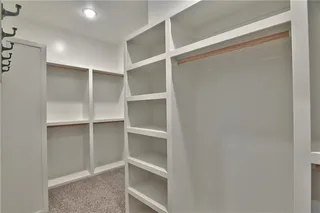 Large Master Closet with Hooks conveniently.  Picture is of Actual Home. connects to Laundry Room.