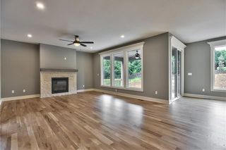 Great Room with Hardwood Floors and Stone Front Gas Fireplace with Mantel