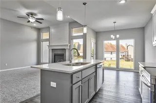 View of Kitchen/Dining Room. Upgraded Quartz Counter Tops, Modern Light Fixtures, Stainless Steel Appliances, Walk in Pantry and Hard Wood Floors. Access to Deck is from Dining Room. Picture is of Actual Home. 