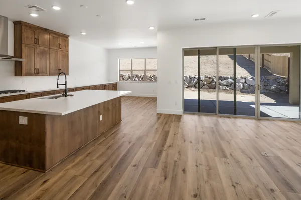 Open kitchen and great room with luxury vinyl plank flooring and a Milgard Trinsic four-panel sliding door to the patio.