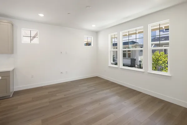 Bright great room with large windows, recessed lighting and luxury vinyl plank flooring.