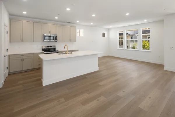 Open kitchen and living area with large center island and abundant natural light.