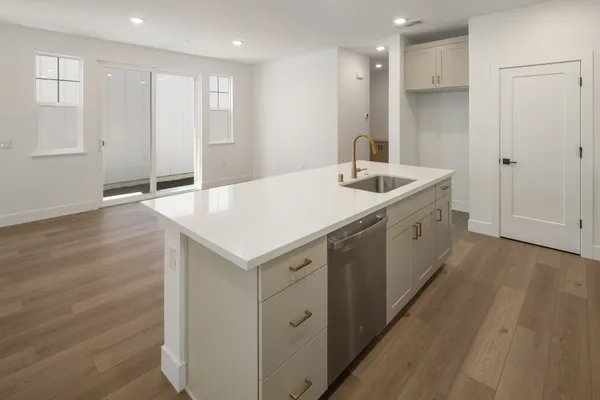 Kitchen island overlooking the dining area with light cabinetry and stainless steel appliances.