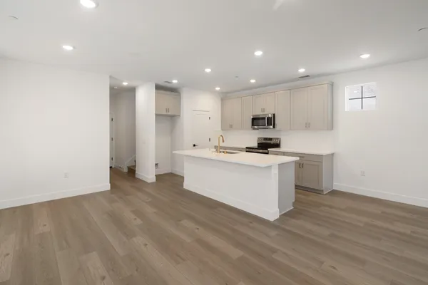 Open-concept kitchen and dining area with center island, light cabinetry and recessed lighting.