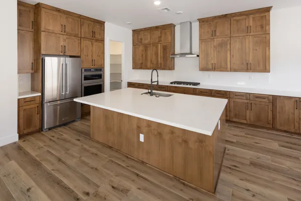 Kitchen with wood cabinetry, white countertops, and KitchenAid stainless steel appliances.
