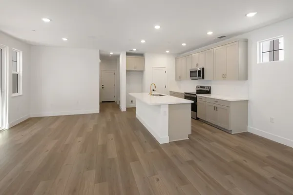 Open kitchen and dining area with center island and luxury vinyl plank flooring.