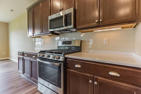 Kitchen with stainless steel microwave and range oven at The Villas at Iron Mill: James