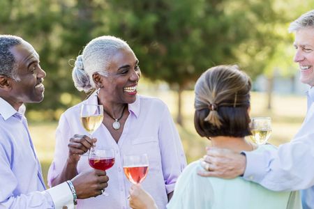 Group of retired friends enjoying wine outdoors