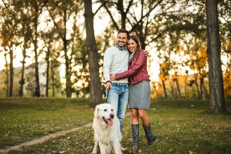 Young couple candidly smiling with their white lab