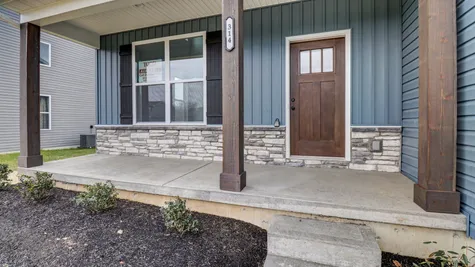 Adding to the Curb Appeal is a 20ft Covered Front Porch with Cedar-Stained Posts & Front Door