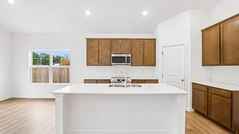 Kitchen of the Chestnut by Arbor Homes with Arid cabinets and a center island