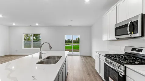 Kitchen island with white cabinets and quartz countertops, Abbey Commons