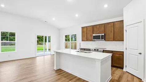 Open concept great room and kitchen of the Chestnut by Arbor Homes with Marina vinyl plank flooring