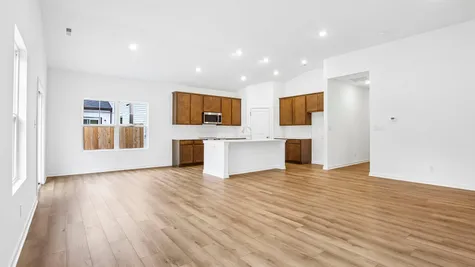 Open concept great room and kitchen of the Chestnut by Arbor Homes with Marina vinyl plank flooring