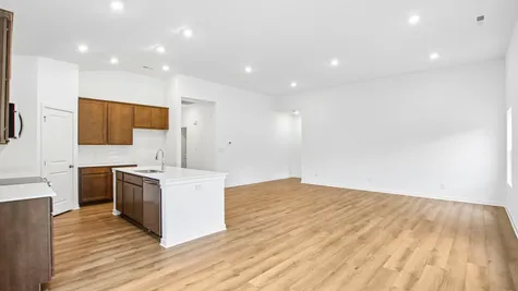 Open concept great room and kitchen of the Chestnut by Arbor Homes with Marina vinyl plank flooring