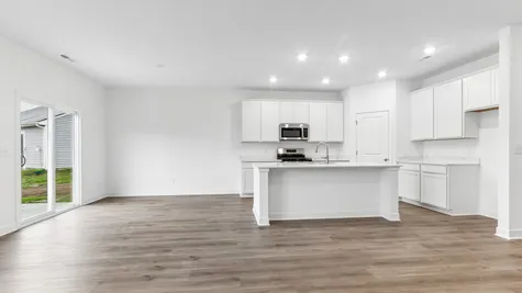 Kitchen with white cabinets and quartz countertops with cafe dining area, Abbey Commons