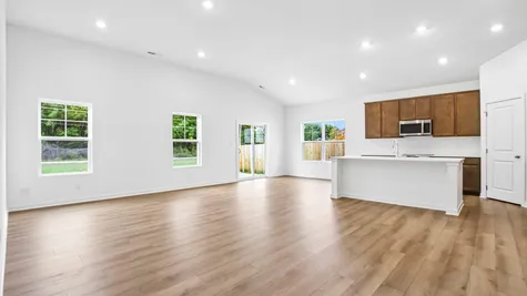 Open concept great room and kitchen of the Chestnut by Arbor Homes with Marina vinyl plank flooring